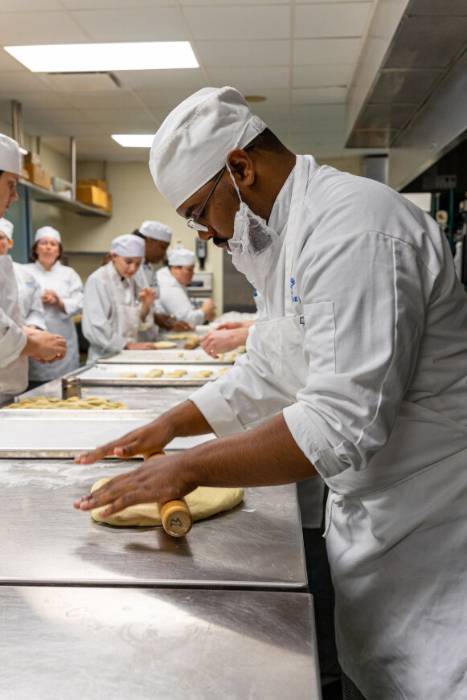 Male student rolling bread