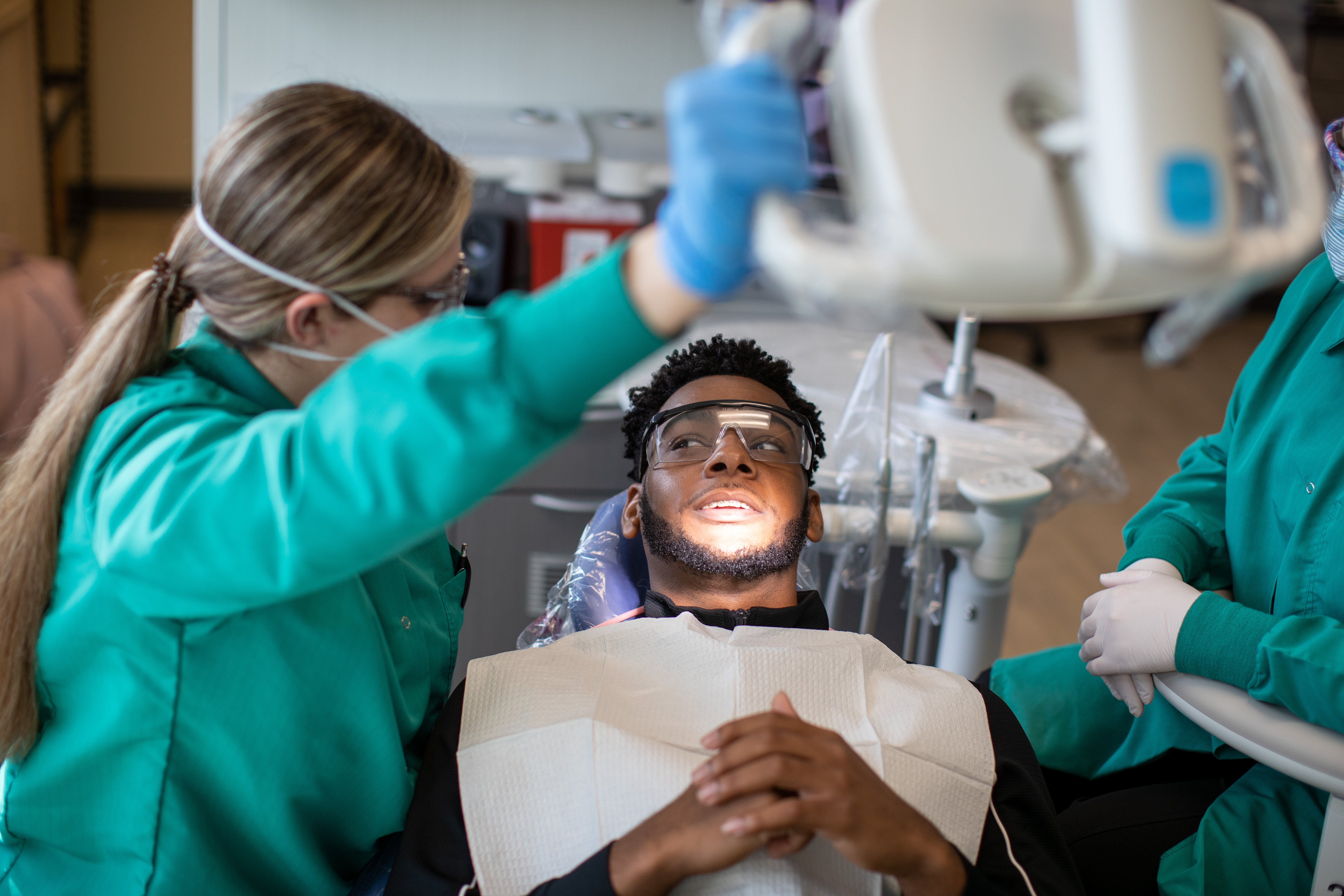 Dental assistant looking at patient mouth