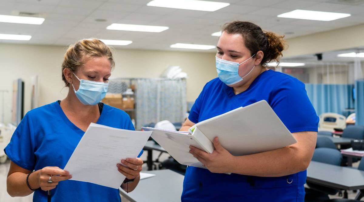 Two nursing looking at paperwork
