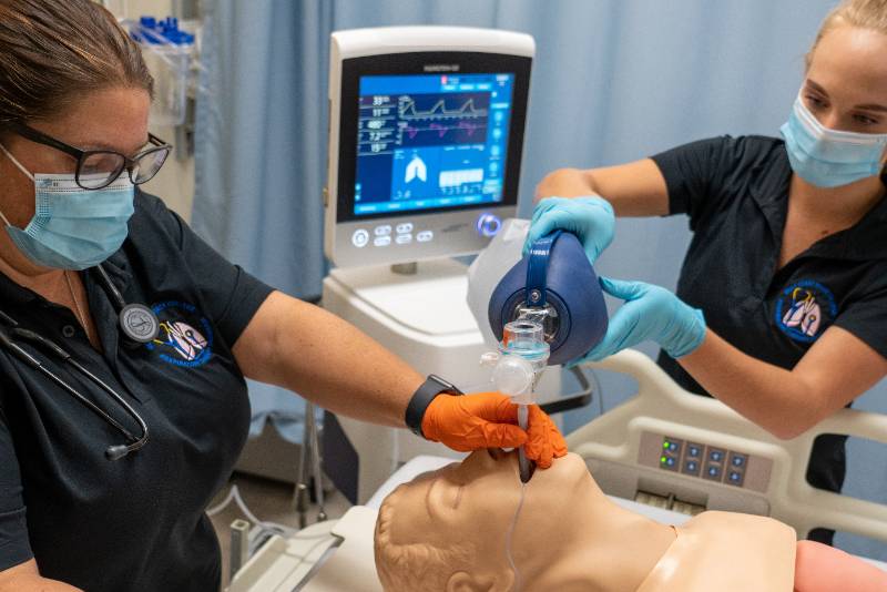 Nurse putting a tube in dummy