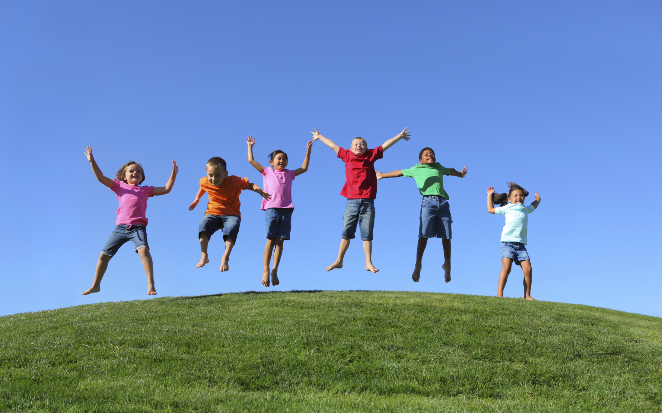 Children holding hands and jumping