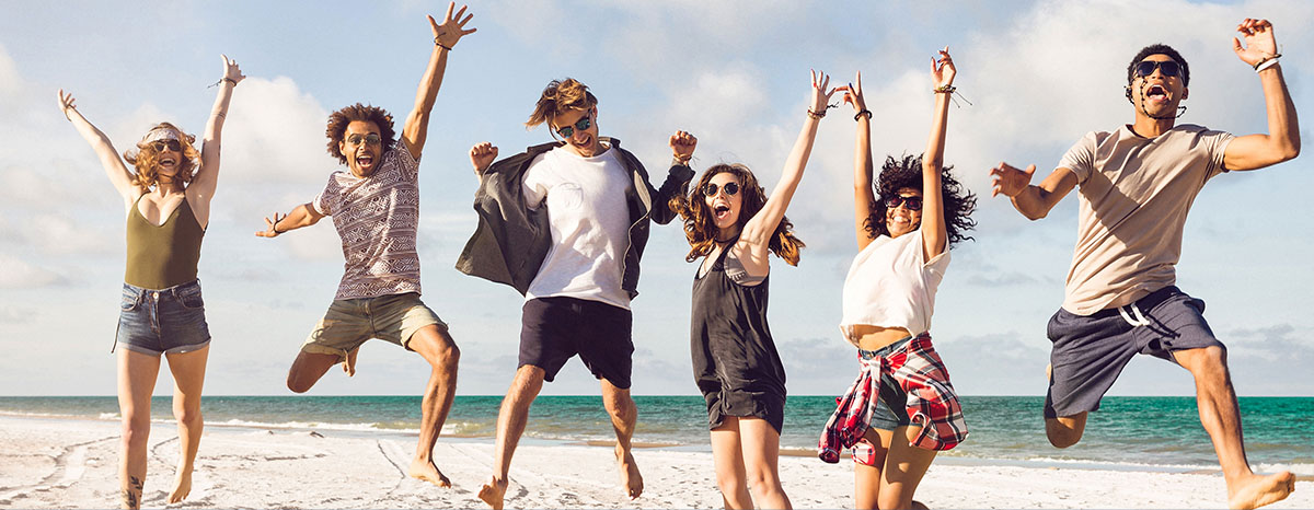 Student jumping on beach