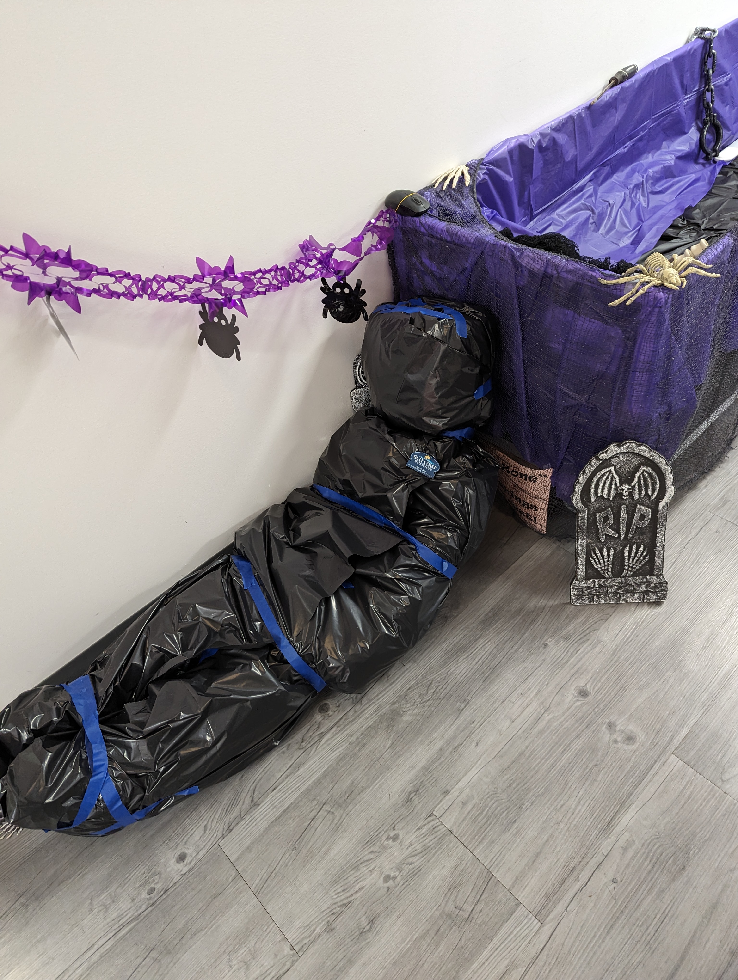 Information Technology Services, ITS Halloween Decorations in GCSC's ITS Building. Dead body next to a coffin.