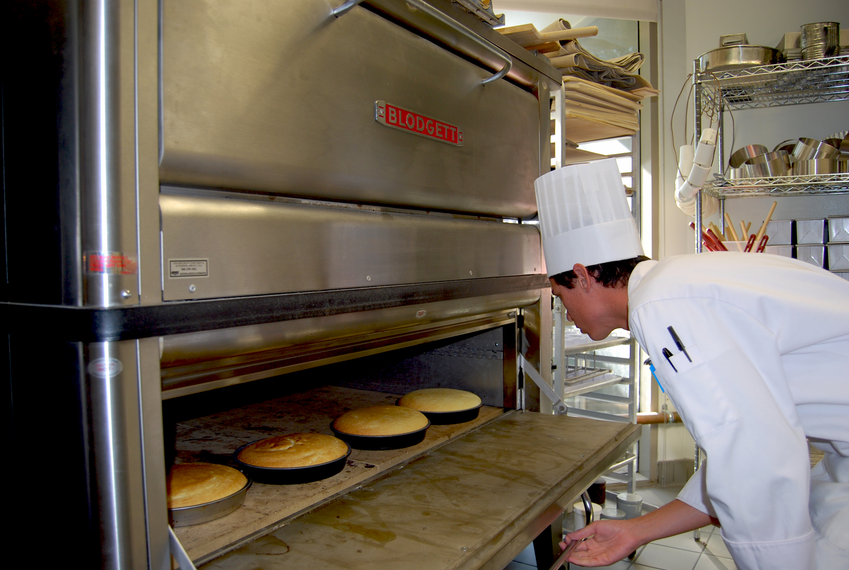 Student putting cake un oven