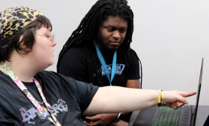 Two students working at laptop together